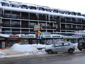 een auto geparkeerd in de sneeuw voor een gebouw bij Olympe - 124 - Studio coquet - 3 pers in Les Deux Alpes