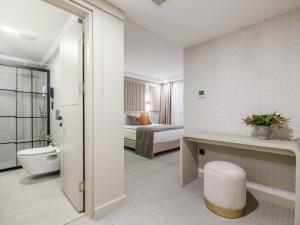 een badkamer met een toilet en een bed in een kamer bij Perla Pura in Izmir