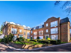 a large brick building on a street at The Green Lodge (Bush Hill Park) in Enfield