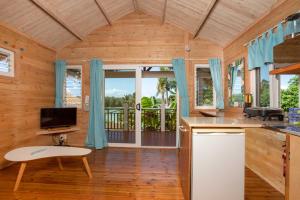 uma cozinha com cortinas azuis e uma grande janela em Muri Motu Outlook em Rarotonga