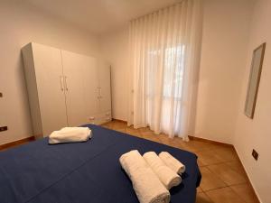 um quarto com uma cama azul com toalhas em Residence Il Pantheon - Zeus em Marina di Fuscaldo