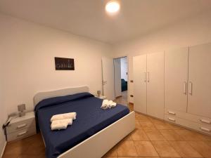 um quarto com uma cama azul e armários brancos em Residence Il Pantheon - Zeus em Marina di Fuscaldo