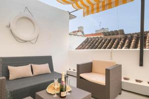 a patio with a couch and a table and chairs at Flores Apartments in Estepona