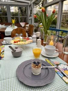 a table with a breakfast of fruit and orange juice at Land & Leben Pension in Chemnitz