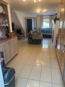 a kitchen and living room with a large white tile floor at Bayview, Dunmore East, County Waterford - Sleeps 12 persons in Dunmore East