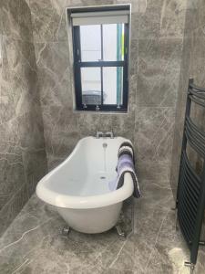uma banheira na casa de banho com uma janela em Bayview, Dunmore East, County Waterford - Sleeps 12 persons em Dunmore East