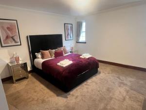een slaapkamer met een bed met een rood dekbed bij Coylebrae House in Ayr