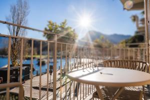 a table and chairs on a balcony with the sun at LUXURY SUITES ROCOPOM - Lake Front in Lecco