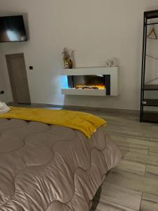 a living room with a fireplace and a bed at Pergamena Bianca in Cava deʼ Tirreni