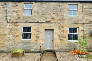 un edificio in mattoni con una porta e tre finestre di 2Fountains Cottage - Hadrian's Wall a Greenhead Altre 22 foto