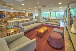 a lobby with couches and tables and a bar at City Express by Marriott Toluca in Toluca