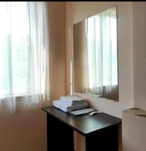 a bathroom with a mirror and a table with towels at MG Guest House in Ijevan
