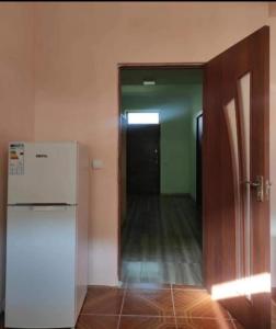 an empty room with a refrigerator and a hallway at MG Guest House in Ijevan
