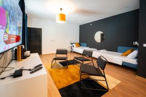 Habitación con cama, sillas y TV. en Cozy Nook en Novi Sad