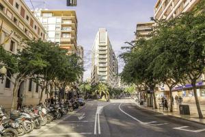 een straat met een rij geparkeerde motorfietsen bij Apartamento Rambla 36 in Alicante