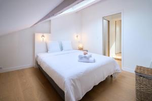 a bedroom with a white bed with a towel on it at LE BLUM COEUR - Hyper Centre Nantes in Nantes