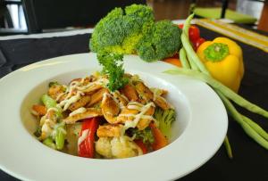 a white bowl of food with broccoli and other vegetables at h78 in Hulhumale
