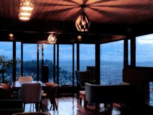 een kamer met een tafel, stoelen en ramen bij Andriana Luxury in Antananarivo