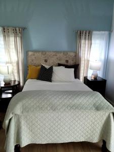 a bedroom with a large white bed with two lamps at Retreat2Jamaica in Runaway Bay