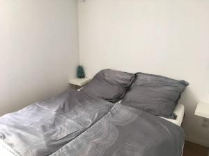 a bed with gray sheets and pillows in a bedroom at casita limon in Palma de Mallorca