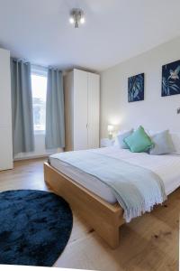 a bedroom with a large bed and a blue rug at Luxury Apartment in Kensal Rise in London