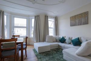 a living room with a white couch and a table at Luxury Apartment in Kensal Rise in London