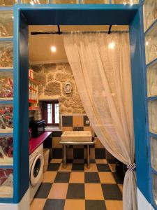 a kitchen with a table and a curtain in a room at Casa Bodega Sacra in Pereiro de Aguiar
