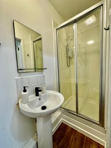 a white bathroom with a sink and a shower at Rooms Near Me - Apartment 4, Smart Tv, Free Parking in Halesowen