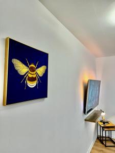 a picture of a bee hanging on a wall at Rooms Near Me - Apartment 4, Smart Tv, Free Parking in Halesowen