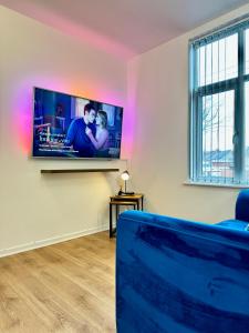 a living room with a flat screen tv on a wall at Rooms Near Me - Apartment 4, Smart Tv, Free Parking in Halesowen