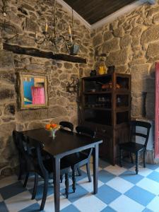 uma sala de jantar com mesa e cadeiras e uma parede de pedra em Casa Bodega Sacra em Pereiro de Aguiar
