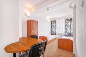 een kamer met een tafel, een bed en een bureau bij Hotel Biała Gwiazda in Krakau