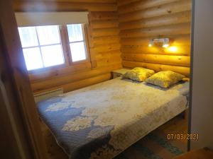 a bedroom with a bed in a log cabin at Cottage-karaoke Koivikko in Äänekoski