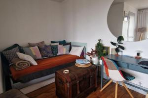 um quarto com uma cama e uma mesa com uma mala em Appartement cosy avec balcon et vue dégagée em Montreuil