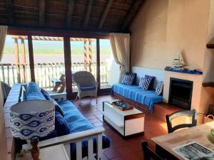 a living room with a blue couch and a fireplace at Breede River Lodge in Witsand
