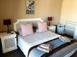 a bedroom with a bed with two lamps and two towels at Breede River Lodge in Witsand