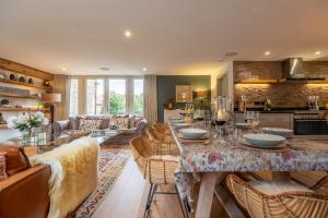 a kitchen and living room with a table and chairs at Horse Yard Barn in Warham