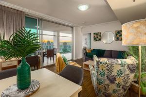 a living room and dining room with a vase on a table at Luxury Oasis with Indulgent River Views in Brisbane