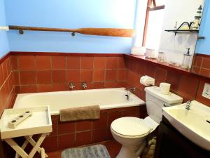 a bathroom with a tub and a toilet and a sink at Breede River Lodge in Witsand