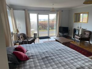 a bedroom with a large bed and a large window at Lakeland Midsummer Lakehouse in Oughterard