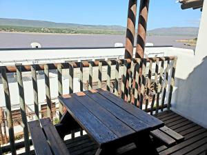 eine Holzbank auf dem Balkon in der Unterkunft Breede River Lodge in Witsand