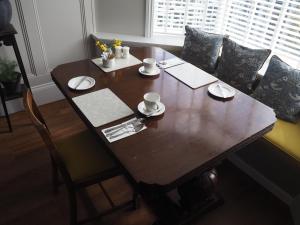 a wooden table with cups and saucers on it at South View Guest House in Lynton
