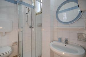 a bathroom with a sink and a mirror and a toilet at Hotel Mia in Rimini