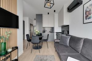 ein Wohnzimmer mit einem Sofa und einem Tisch in der Unterkunft Lion Apartments - SCALA City Center Apartments&Studio IIIB in Danzig