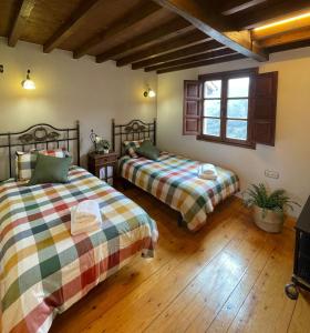 Duas camas num quarto com pisos em madeira em Entre horreos em Carbajal