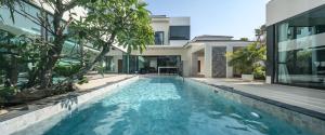 a swimming pool in front of a house at Sun Diego Resort Pool Villa in Jomtien Beach