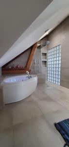 La salle de bains est pourvue d'une baignoire blanche. dans l'établissement Grange du petit bonhomme, à Hésingue