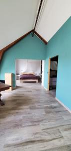 une pièce vide avec un lit et un mur bleu dans l'établissement Grange du petit bonhomme, à Hésingue