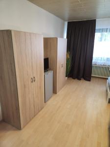 an empty room with wooden cabinets and a television at Gästewohnung in Adolf Grimme Stadt Marl in Marl