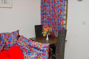 een eetkamer met een tafel en een rood en blauw gordijn bij Cozzy one bedroom apartment in Ukunda